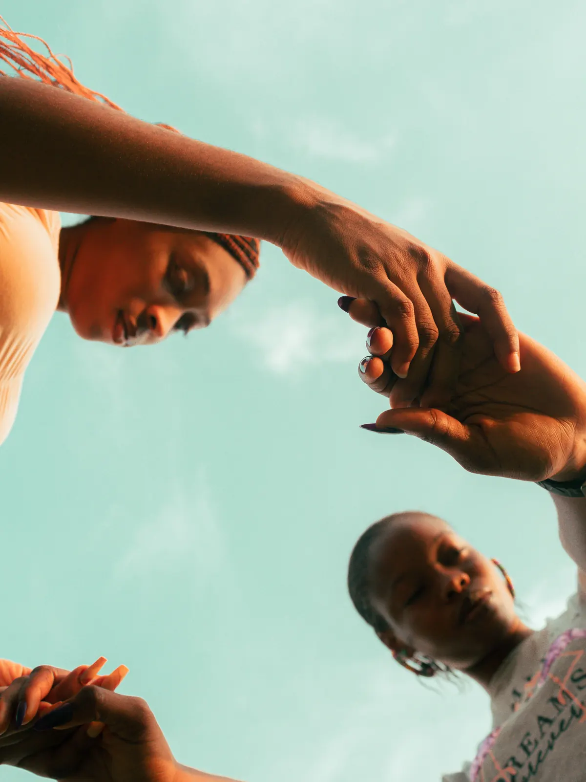 Two women reaching out to take each other’s hands